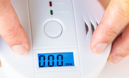 Person testing a carbon monoxide alarm